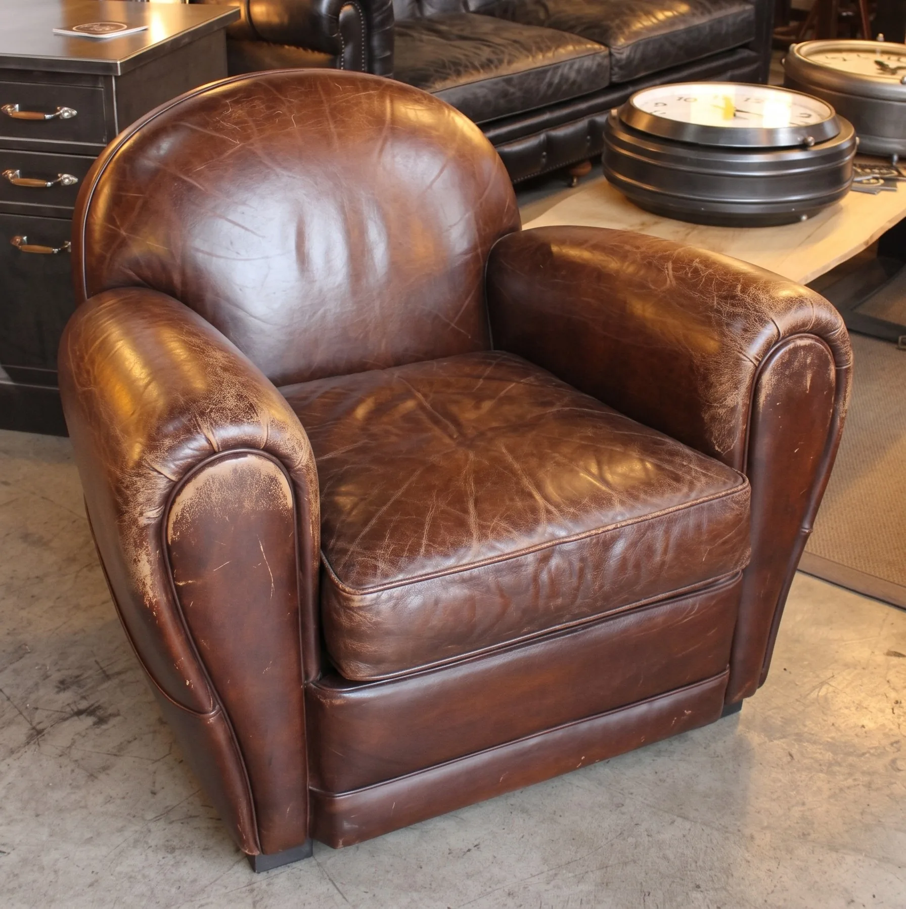Cracked, worn Art-Deco brown leather club chair before restoration